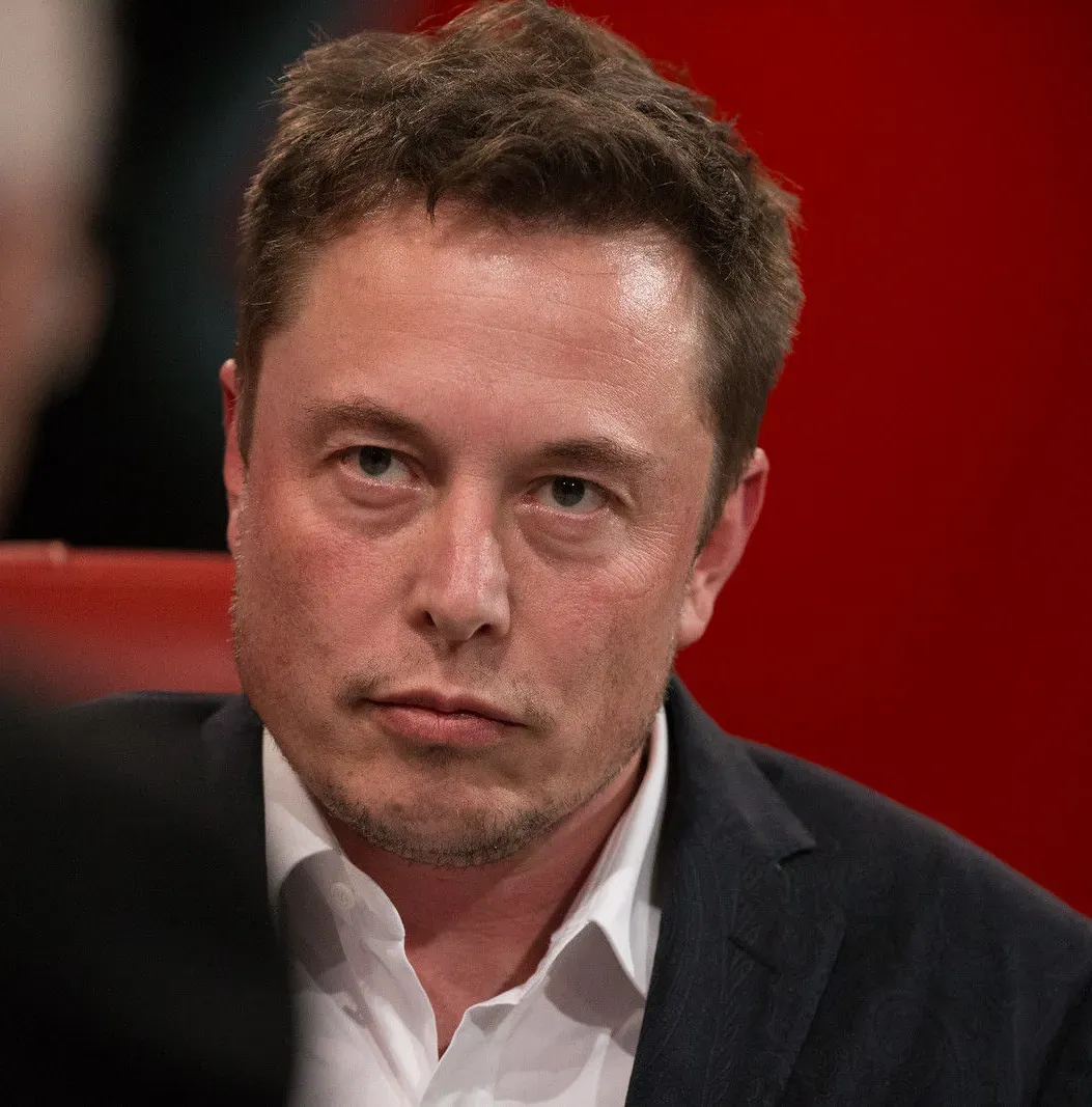 Elon Musk photographed from the chest up, facing the camera.